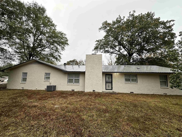 back of house with a yard and central air condition unit