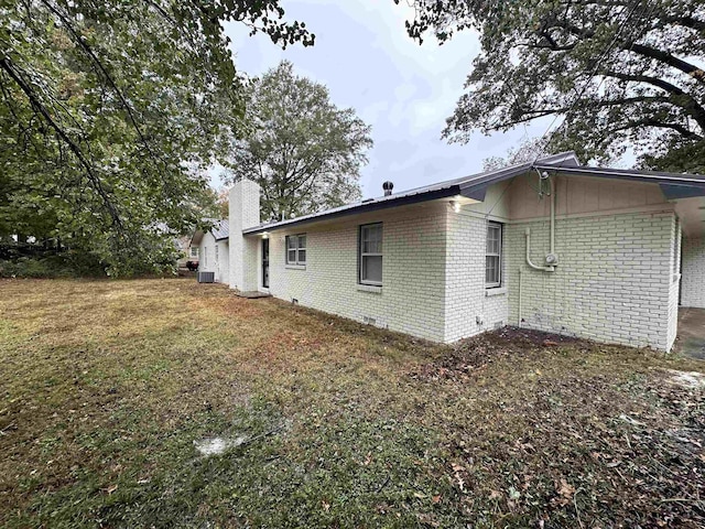 view of property exterior with cooling unit and a lawn