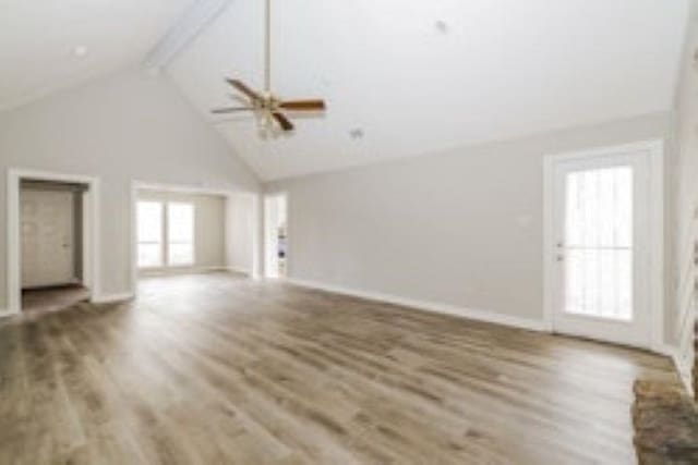 unfurnished living room with beam ceiling, hardwood / wood-style flooring, and high vaulted ceiling