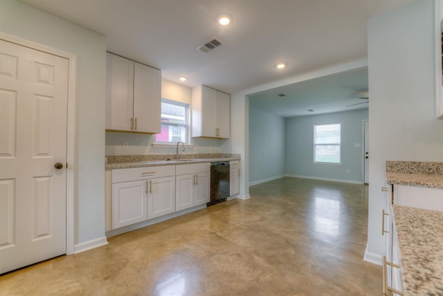 kitchen with white cabinetry, black dishwasher, sink, and light stone countertops