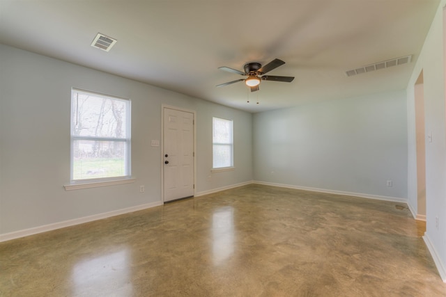 unfurnished room with plenty of natural light, concrete flooring, and ceiling fan