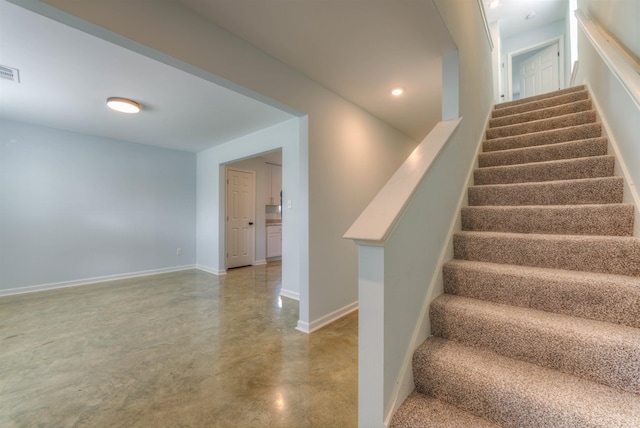 stairs featuring concrete flooring