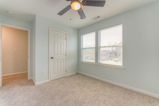 unfurnished bedroom with ceiling fan and light colored carpet