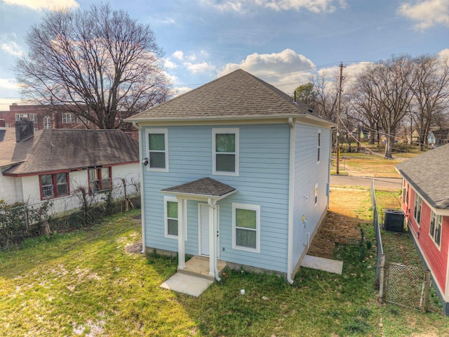 view of property with a front lawn and central air condition unit