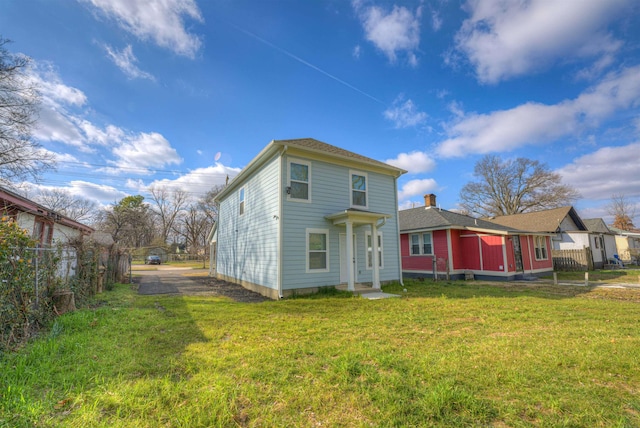 rear view of property featuring a lawn