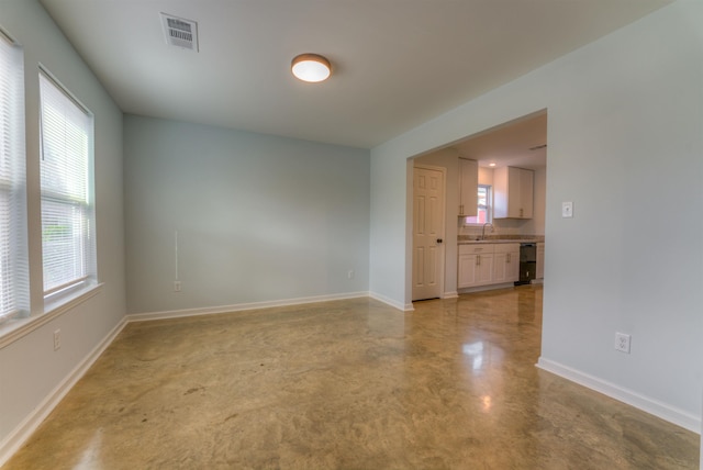 unfurnished room featuring sink and a wealth of natural light