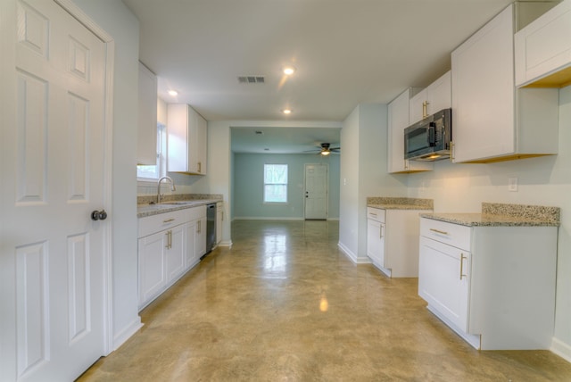 kitchen with sink, white cabinetry, light stone counters, dishwasher, and ceiling fan