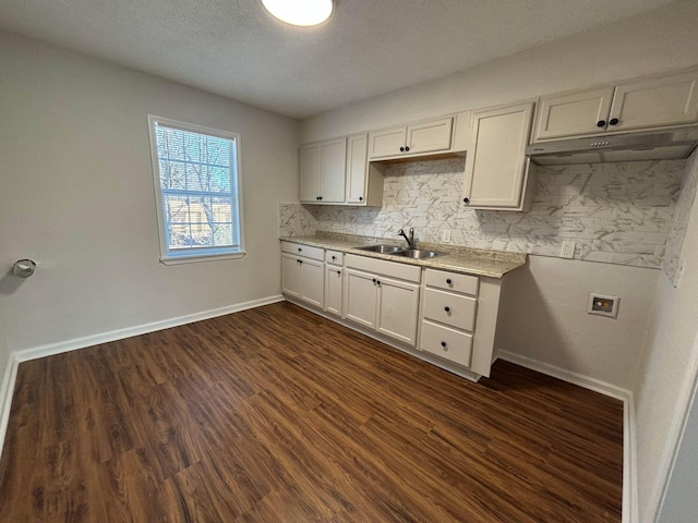 kitchen with dark hardwood / wood-style flooring, sink, decorative backsplash, and white cabinets