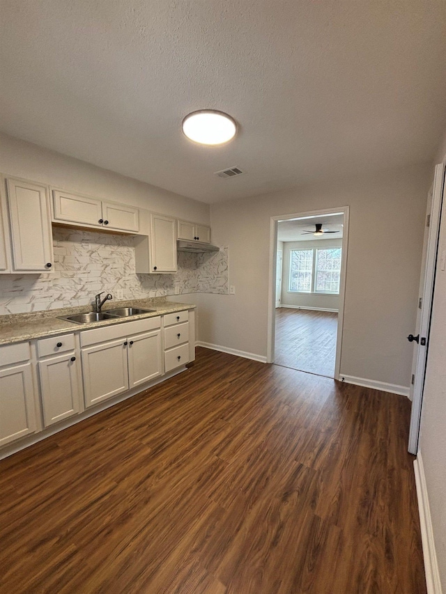 kitchen featuring dark hardwood / wood-style flooring, sink, and white cabinets