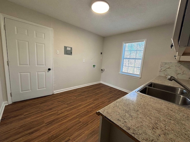 interior space featuring sink, hookup for a washing machine, cabinets, a textured ceiling, and dark hardwood / wood-style flooring