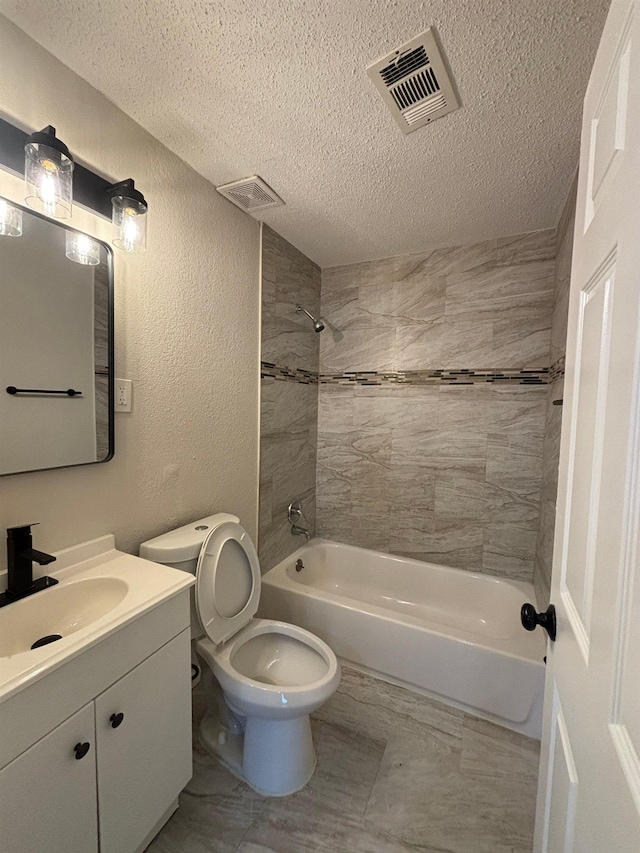 full bathroom with tiled shower / bath, vanity, a textured ceiling, and toilet