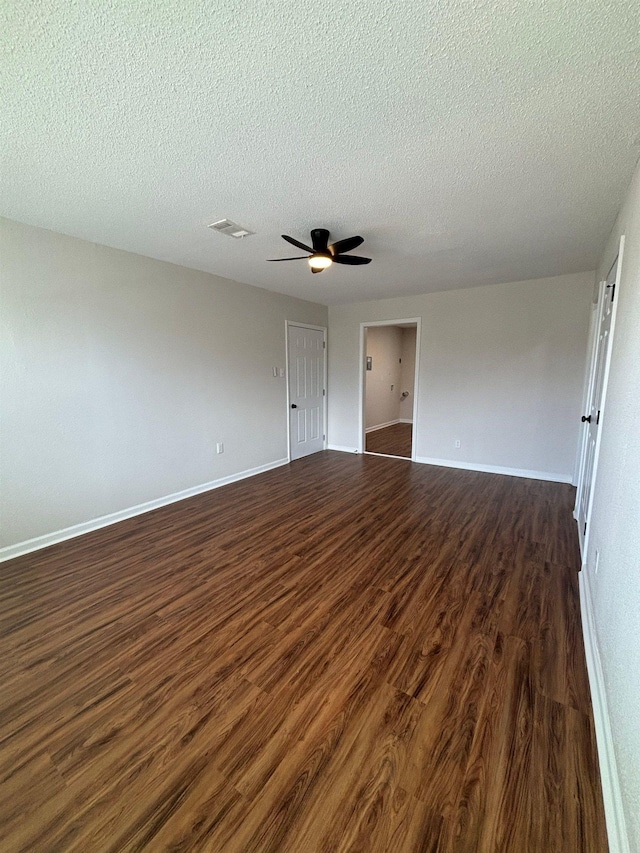 spare room with dark hardwood / wood-style flooring, a textured ceiling, and ceiling fan