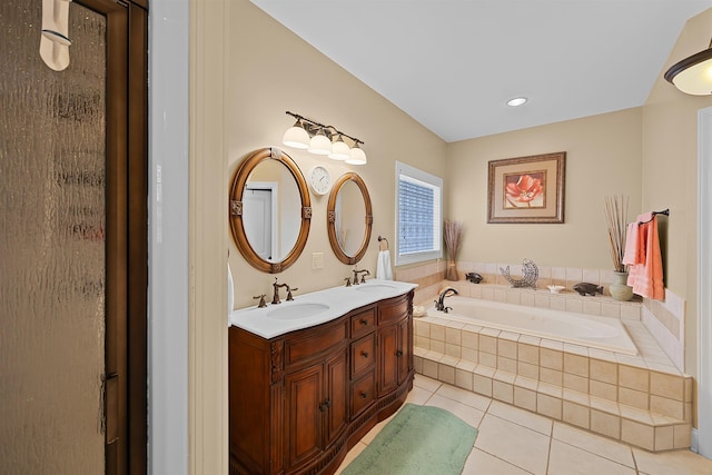 bathroom featuring vanity, tile patterned flooring, and tiled tub