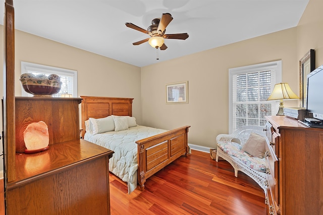 bedroom with dark hardwood / wood-style floors and ceiling fan