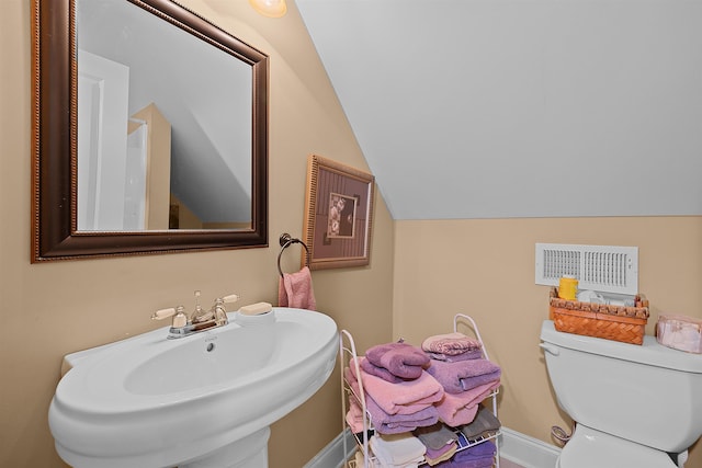 bathroom featuring vaulted ceiling, sink, and toilet