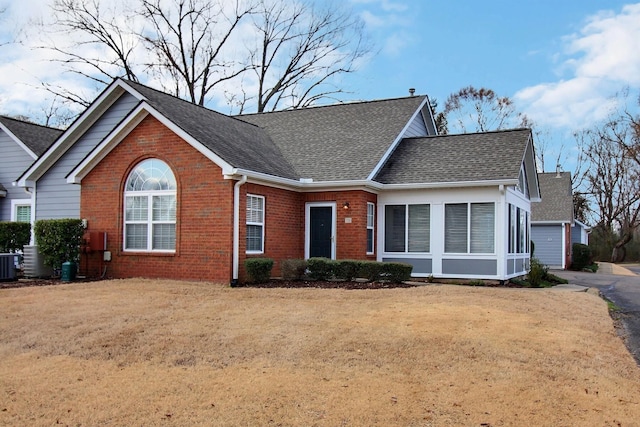 view of front of house featuring a garage, a front yard, and central air condition unit