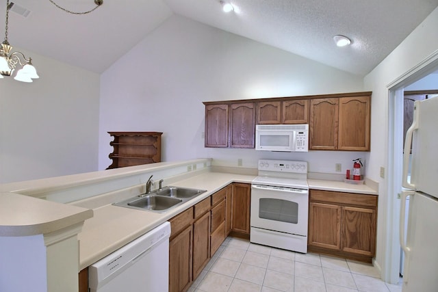 kitchen featuring lofted ceiling, sink, hanging light fixtures, light tile patterned floors, and white appliances