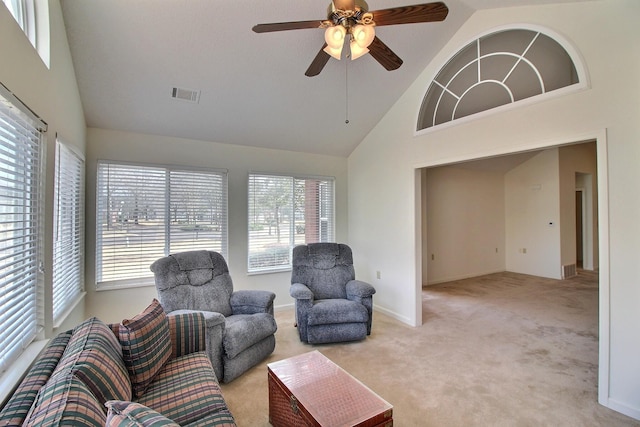 living room featuring plenty of natural light, light colored carpet, and high vaulted ceiling