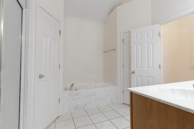 bathroom with tile patterned floors, a tub to relax in, and vanity