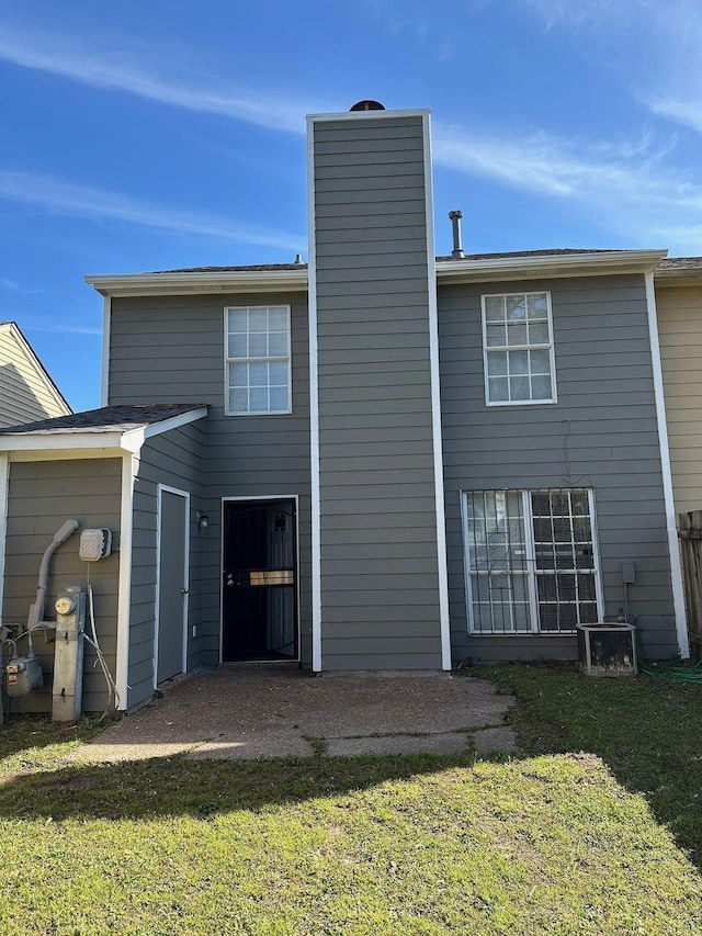 back of property with a patio area, central air condition unit, and a lawn