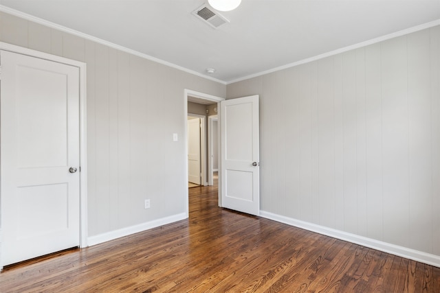 unfurnished bedroom featuring crown molding and dark wood-type flooring