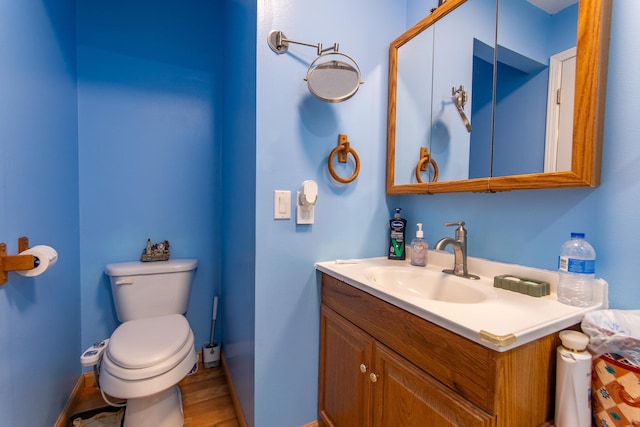 bathroom featuring vanity, hardwood / wood-style floors, and toilet