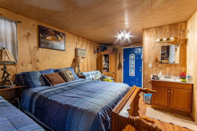 bedroom with sink, wood ceiling, and wood walls