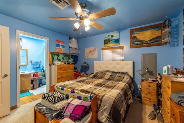 bedroom with light carpet, ceiling fan, and ensuite bathroom