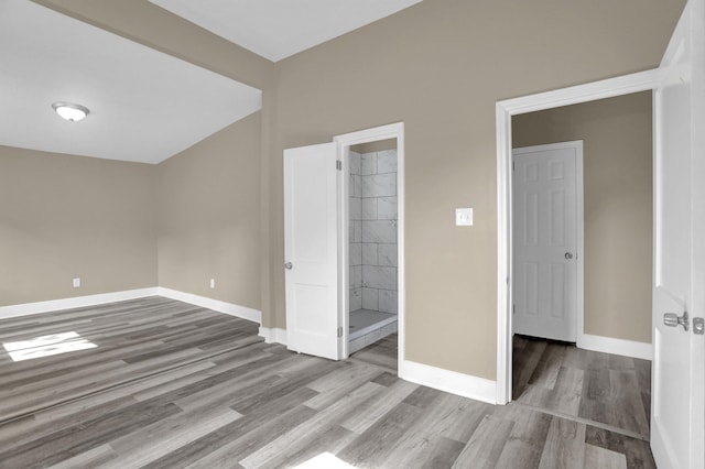 unfurnished bedroom featuring connected bathroom and light wood-type flooring