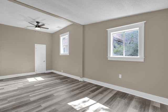 spare room featuring ceiling fan, light hardwood / wood-style floors, and a textured ceiling