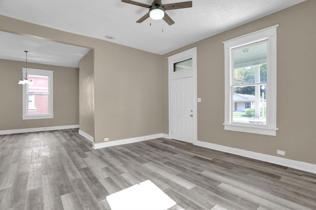 interior space featuring ceiling fan, light hardwood / wood-style flooring, and a textured ceiling