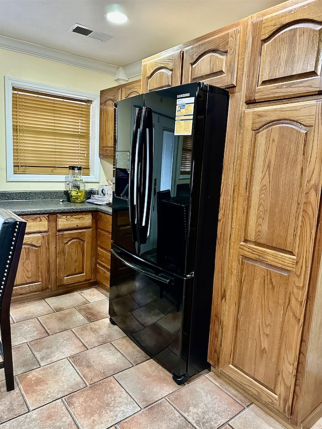 kitchen featuring black refrigerator and ornamental molding