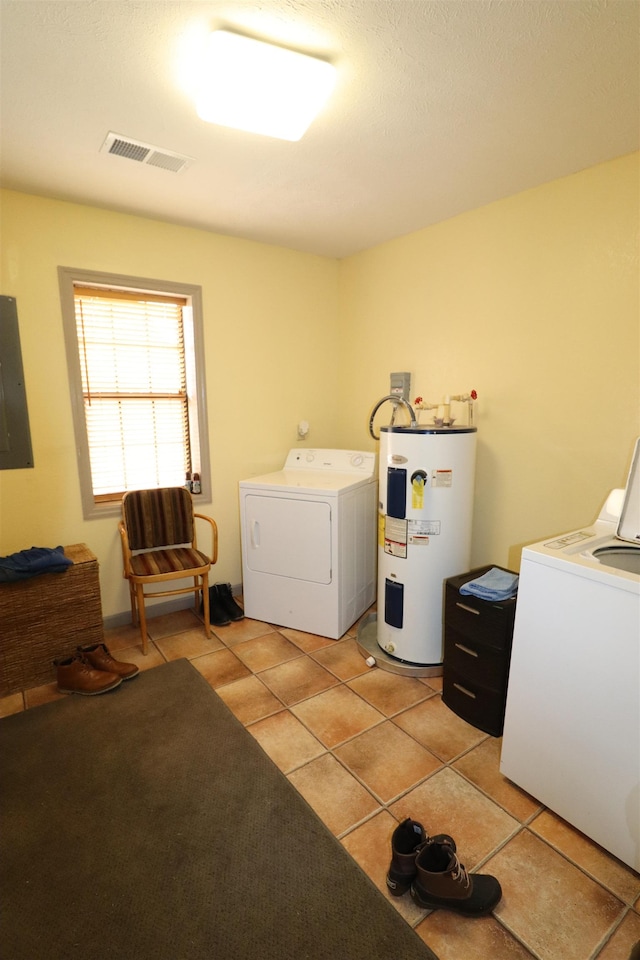 laundry area featuring water heater, separate washer and dryer, light tile patterned floors, and electric panel