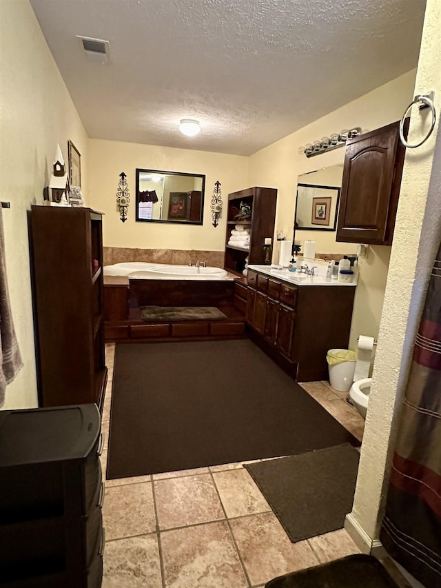 bathroom featuring vanity, toilet, and a textured ceiling