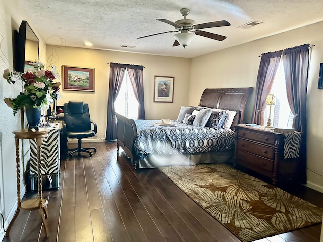 bedroom with ceiling fan, dark hardwood / wood-style floors, and a textured ceiling