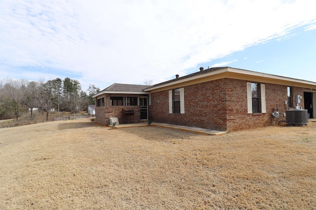 rear view of house with a yard and central air condition unit