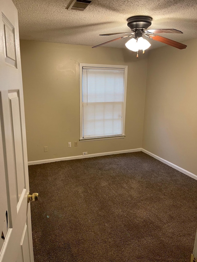 carpeted empty room featuring ceiling fan and a textured ceiling