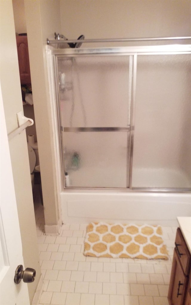 bathroom featuring tile patterned floors, vanity, and bath / shower combo with glass door