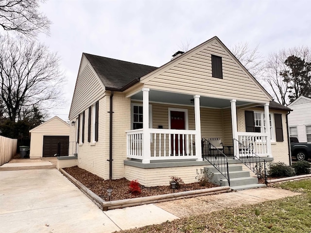 bungalow-style house featuring covered porch, an outdoor structure, and a garage