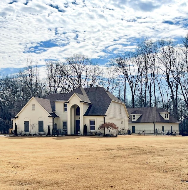 view of front of house with a front yard and roof with shingles