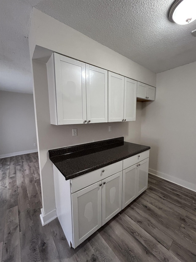 kitchen featuring white cabinetry, dark wood-type flooring, and a textured ceiling