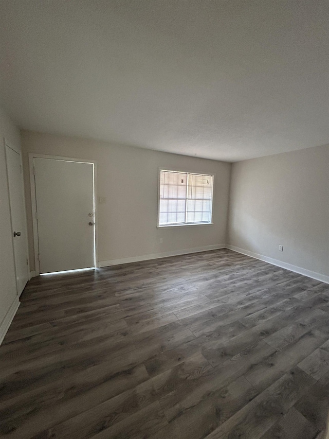 spare room with dark wood-type flooring