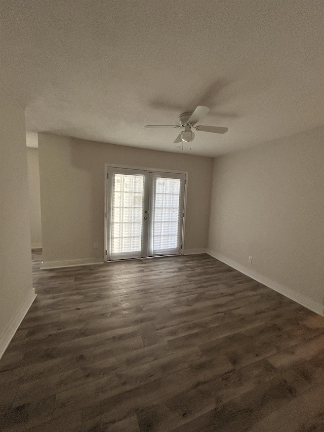 empty room with ceiling fan, dark hardwood / wood-style floors, and a textured ceiling