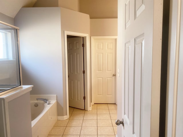 bathroom with tile patterned flooring and a bath