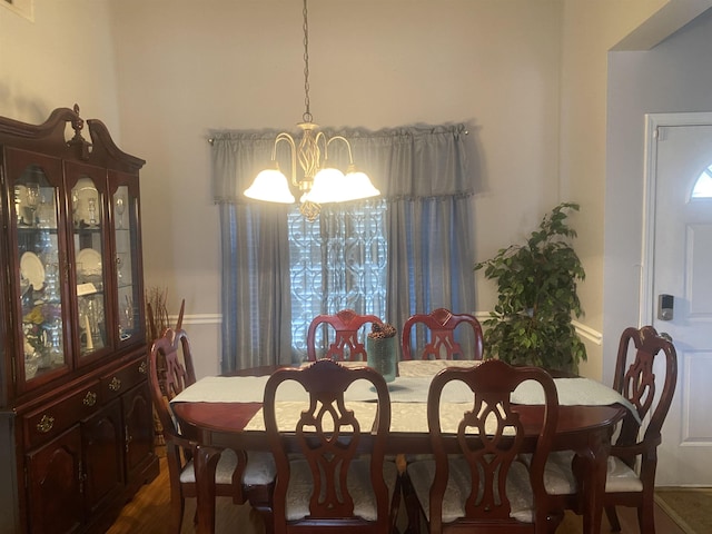 dining area featuring dark hardwood / wood-style flooring and a chandelier