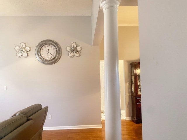 hallway with hardwood / wood-style flooring and ornate columns