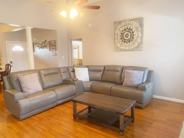 living room with light hardwood / wood-style flooring, decorative columns, and ceiling fan