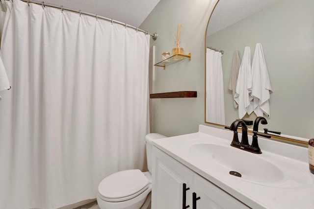 bathroom featuring vanity, a textured ceiling, and toilet