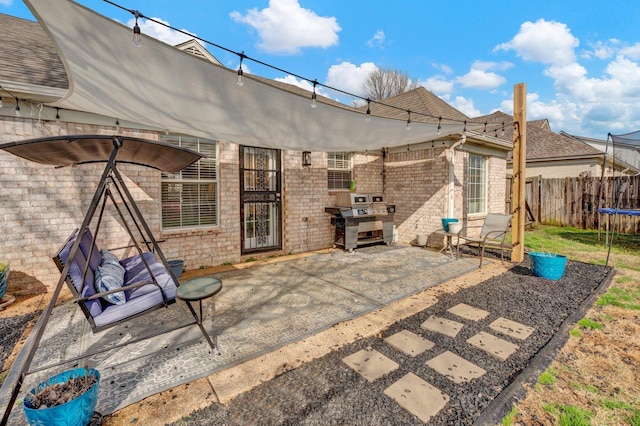 view of patio / terrace with a grill and a trampoline