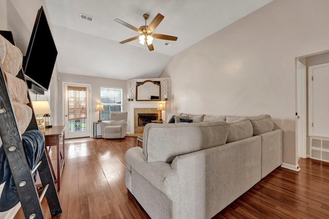 living room featuring ceiling fan, a fireplace, dark hardwood / wood-style flooring, and vaulted ceiling